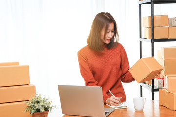 Shipping shopping online, young attractive entrepreneur business woman working at home office with many packaging cardboard box