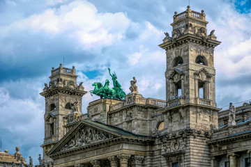 Budapest / Hungary - August 29 2019: Facade of the historic luxury building of the Ethnographic Museum in Budapest, Hungary. Ancient building with columns against the blue sky and green city park