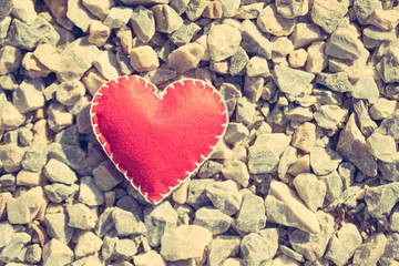 Stitched red heart on a gravel background