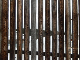 a fragment of a wooden fence, darkened by humidity in the open air with a wonderful manifestation of the pattern of a tree