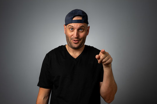 Man In Black Vneck Teeshirt And Backwards Hat