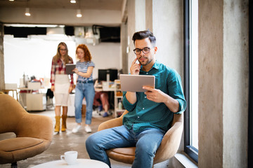 Young man using technology, digital tablet in corporate business office