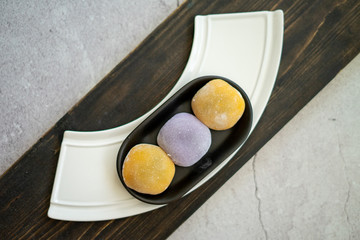 Multi-colored Japanese Mochi in rice dough and on a wooden background. Traditional Japanese dessert.