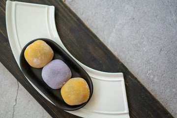 Multi-colored Japanese Mochi in rice dough and on a wooden background. Traditional Japanese dessert.