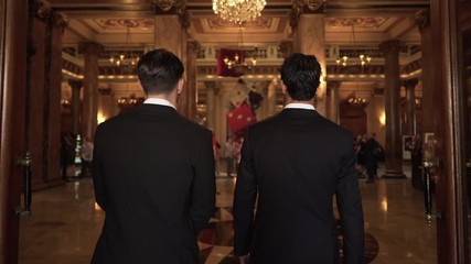 Epic slow motion shot of two men in suits entering casino hall in Monte Carlo, Monaco - Powered by Adobe