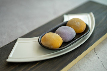 Multi-colored Japanese Mochi in rice dough and on a wooden background. Traditional Japanese dessert.