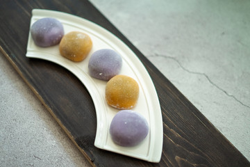 Multi-colored Japanese Mochi in rice dough and on a wooden background. Traditional Japanese dessert.