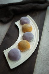 Multi-colored Japanese Mochi in rice dough and on a wooden background. Traditional Japanese dessert.