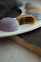 Multi-colored Japanese Mochi in rice dough and on a wooden background. Traditional Japanese dessert.