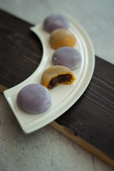 Multi-colored Japanese Mochi in rice dough and on a wooden background. Traditional Japanese dessert.