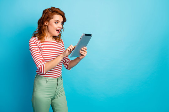 Portrait of astonished funky woman use tablet search incredible sales discounts in formation impressed scream wow omg wear casual style pullover isolated blue color background