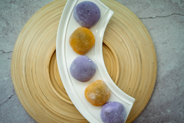 Japanese Mochi in rice dough and on a beautiful bamboo plate and concrete background. Traditional Japanese dessert.