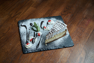 Close up on tasty slice of Delicate Airy Cheesecake on wooden background. delicious dessert cake after dinner. Food photo background for recipe or menu