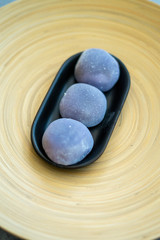 Japanese Mochi in rice dough and on a beautiful bamboo plate and concrete background. Traditional Japanese dessert.