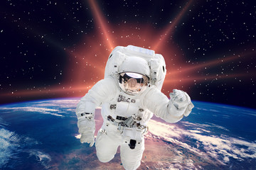 Gorgeous space panorama with the sunrise over the Earth. Astronaut in outer space. The elements of...
