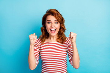 Fototapeta premium Portrait of ecstatic girl win desire wish lottery goal scream yeah raise fists wear good look outfit jumper isolated over blue color background