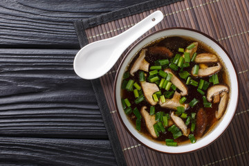 Traditional Japanese soup with shiitake mushrooms and green onions close-up in a bowl. Horizontal top view