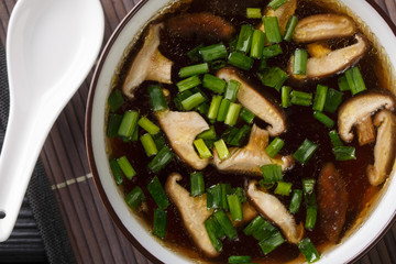 Dietary soup with shiitake mushrooms and green onions close-up in a bowl. Horizontal top view