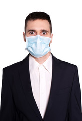 A young man in a medical mask with a scared face.