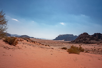 Panoramic view of rocky mountains and red sand in the Jordanian desert of Wadi Rum.
