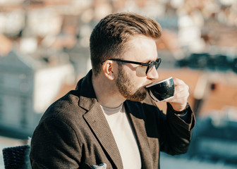 One caucasian man drinks coffee from cup at cafe