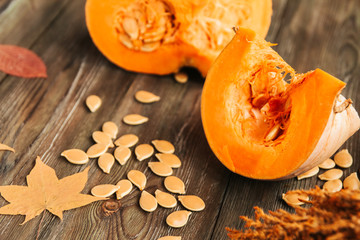  Pumpkin slices, pumpkin seeds and autumn leaves on an old wooden table.