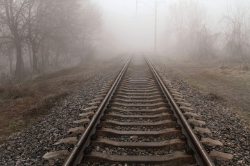 Fototapeta na wymiar The railway goes into dense fog.