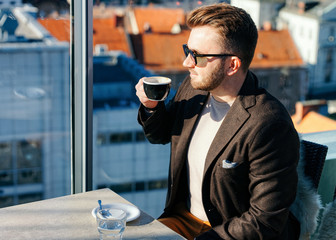 One caucasian man drinking coffee from cup in cafe