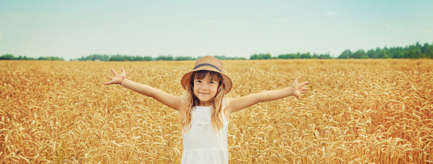 Fototapety  A child in a wheat field. Selective focus.