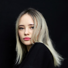 Portrait of beautiful young teenage girl looking serious intense at camera isolated on black background