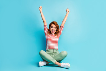 Full size photo of delighted woman sit legs crossed win fortune lottery raise fists scream yeah...