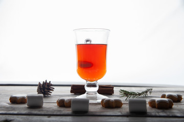 Christmas hot drink - mulled wine, cinnamon stick, star anise and festive Christmas gingerbread cookies over rustic wooden background with copy space, top view