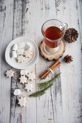 Christmas hot drink - mulled wine, cinnamon stick, star anise and festive Christmas gingerbread cookies over rustic wooden background with copy space, top view