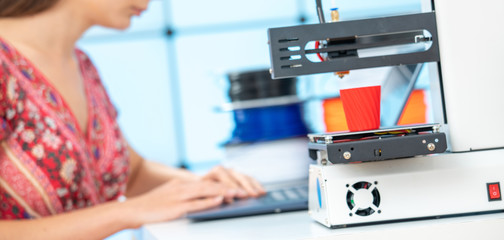 Young female designer works with a home 3D printers