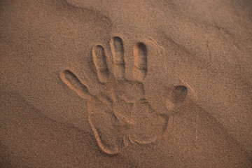 a handprint in the sand of the desert in Oman