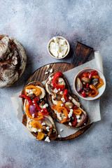 Obraz na płótnie Canvas Roasted vegetables toast with hummus and feta cheese