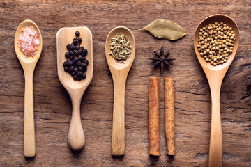 Various spices on rusty wooden background, black pepper, cinnamon stick, star anise, fennel seed