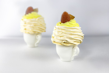 Pavlov’s (pavlova) cakes with strawberries, on a white cup, around strawberries and meringues, white background, high key