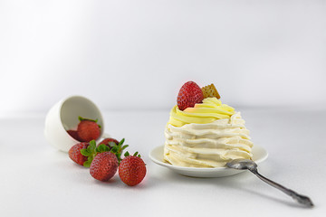 Pavlov’s cake with strawberries, on a white saucer, vintage spoon, strawberries from a white cup, white background, high key
