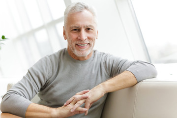 Senior grey-haired bearded businessman sit in cafe.