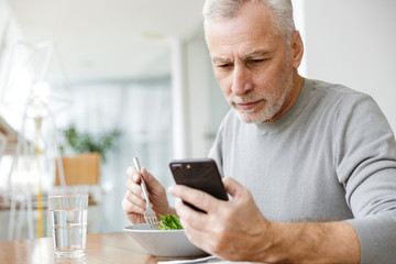 Bearded businessman sit in cafe have a dinner eat salad