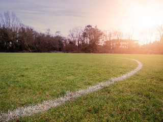Line on a grass for outdoors sports like soccer, rugby hurling at sun set, Warm sun flare, Concept active sport facility.