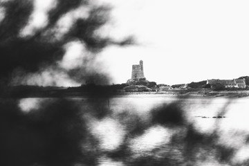 Tower of La Hougue (Tour de La Hougue) seen through blurry tree. Vauban Fortifications. UNESCO...