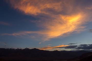 glowing clouds in the sunset sky on the black silhouettes of the mountains