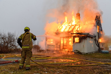 Obraz premium Norwegian firefighter trying to put out flames house on fire