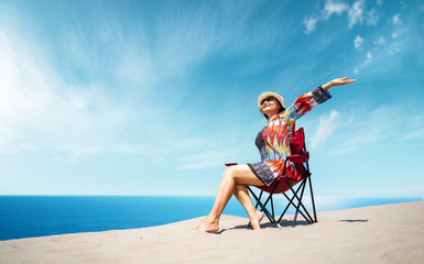 Obraz premium Beautiful sitting woman enjoying the idyllic scene of the sun, sand and sea. Beautyful sandy Patara beach in Antalya. 