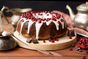 chocolate cake with pomegranate on a wooden table, a cozy breakfast, English tea party, chocolate dessert, delicious Gugelhupf with pomegranate, photo of sweet dishes with free space for text
