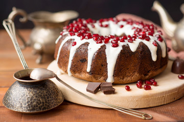chocolate cake with pomegranate on a wooden table, a cozy breakfast, English tea party, chocolate dessert, delicious Gugelhupf with pomegranate, photo of sweet dishes with free space for text