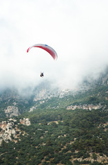 Paraglider flying in the foggy mountains. Landscape, background. Moody picture. Fethiye, Muğla, Turkey. 