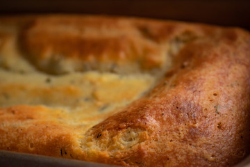 Close-up of fresh rosy ricotta cheese bread with greens and crispy crust